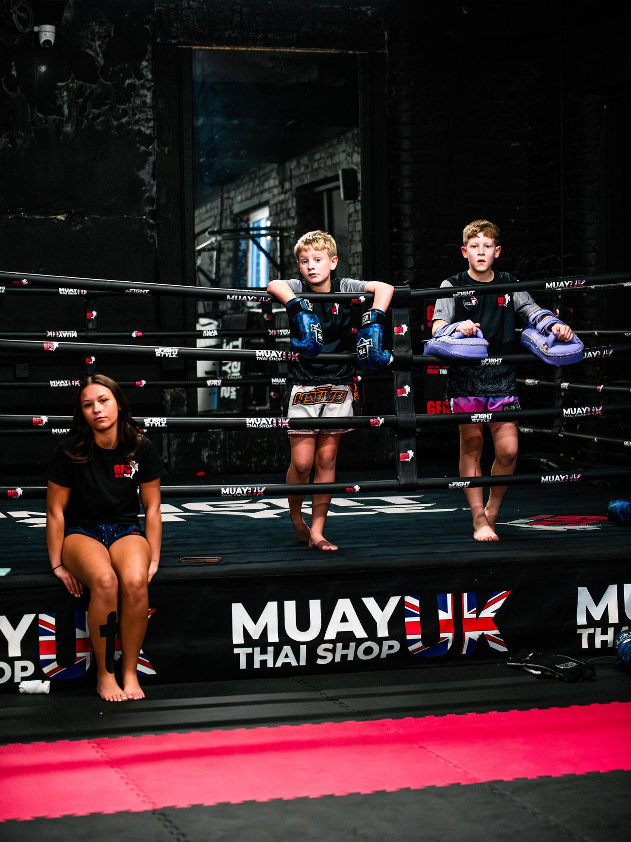 Three junior students taking a break in and beside the GFC boxing ring