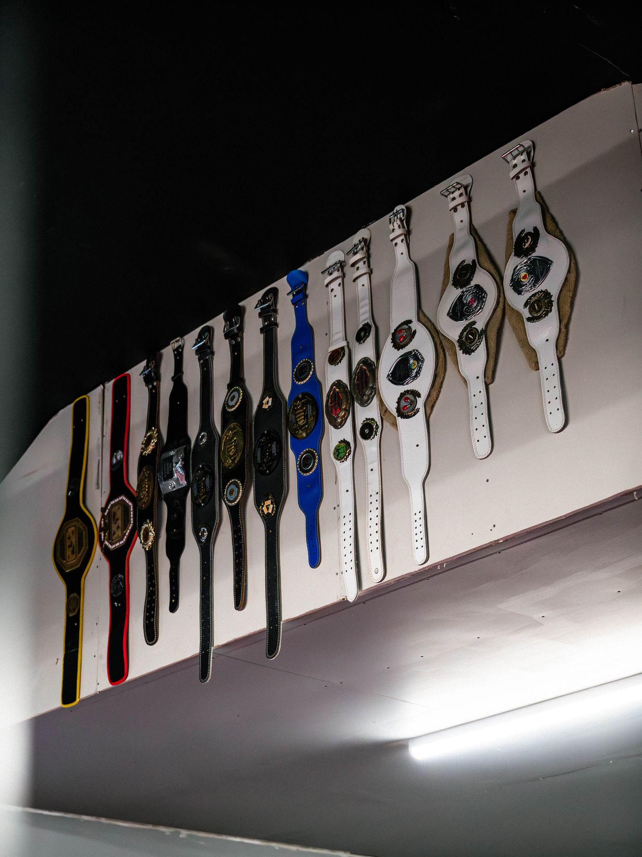 A row of Muay Thai championship belts displayed along the wall at GFC