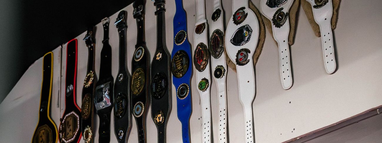 A row of Muay Thai championship belts displayed along the wall at GFC