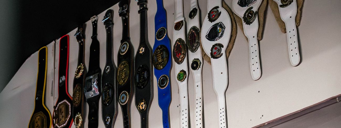 A row of Muay Thai championship belts displayed along the wall at GFC